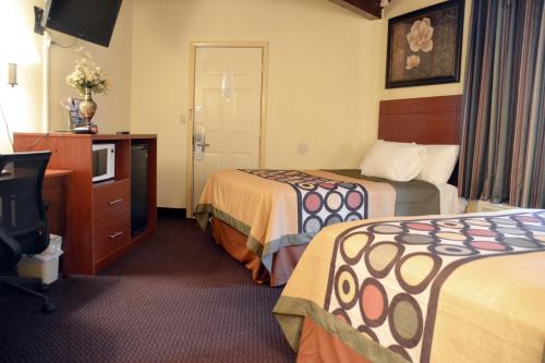 ein Hotelzimmer mit 2 Betten und einem TV in der Unterkunft Scottish Inns Potsdam in Potsdam