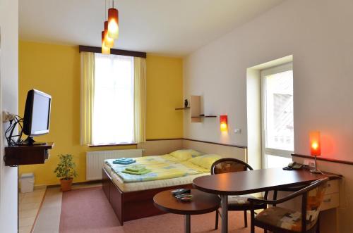 Habitación pequeña con cama y mesa en Residence Salvia, en Liberec