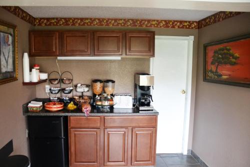 a kitchen with wooden cabinets and a counter top at Scottish Inns Potsdam in Potsdam