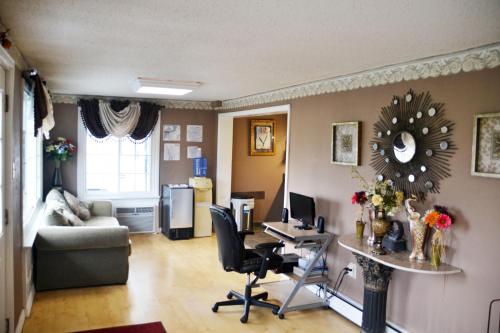 a living room with a desk and a table with chairs at Scottish Inns Potsdam in Potsdam