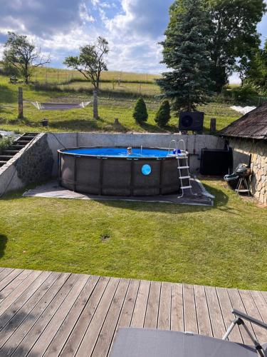 a pool in a yard with a wooden deck at Mała Aleksandra 