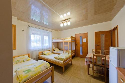 a room with two beds and bunk beds in it at Agroturystyka Nad Tanwią in Budziarze