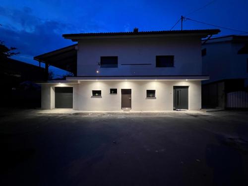 una grande casa bianca con una notte buia di Apartma Naty a Lubiana