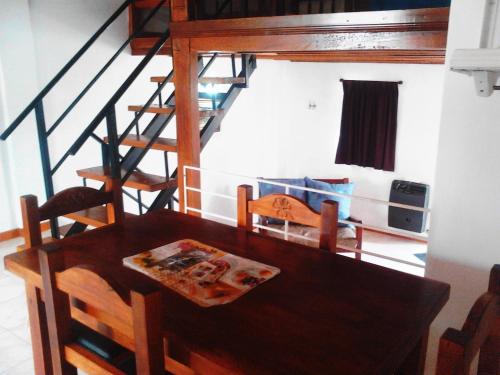 a dining room with a table and a spiral staircase at Cabañas Los Almendros in Merlo