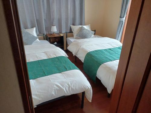 Habitación de hotel con 2 camas y espejo en 白浜 Mizuki-ya en Kamitondacho