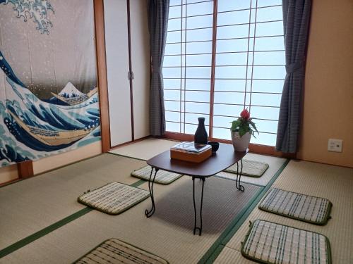 una habitación con una mesa con un jarrón encima en 白浜 Mizuki-ya en Kamitondacho