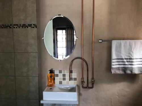 a bathroom with a sink and a mirror at The Bachelor Private Guest Room in Fernglen
