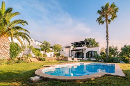 a pool in front of a house with palm trees at Suite Swimming Pool Quinta da Eira 140 years old in Loulé