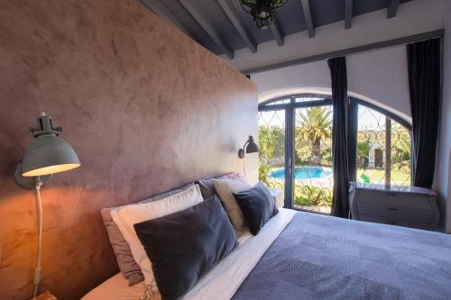 um quarto com uma cama e uma grande janela em Suite Swimming Pool Quinta da Eira 140 years old em Loulé