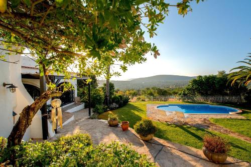 a garden with a swimming pool in a yard at Cosy Farmhouse Quinta da Eira 140 years old in Loulé