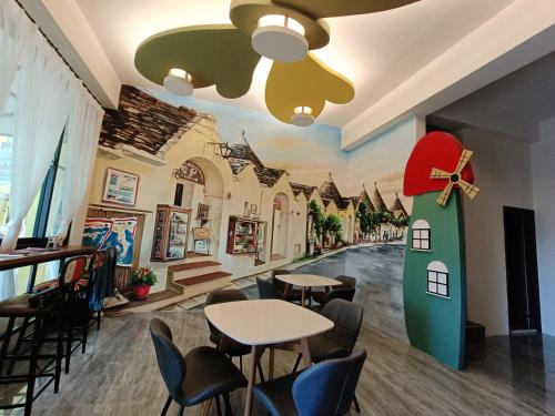 ein Restaurant mit Tischen und Stühlen und einem Gebäudewandbild in der Unterkunft 蘑菇村-童心未泯民宿 in Taitung