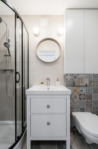 a bathroom with a white sink and a shower at Butas nuomai Šiauliuose in Šiauliai