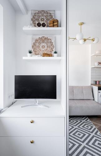 a living room with a tv on a white dresser at Butas nuomai Šiauliuose in Šiauliai