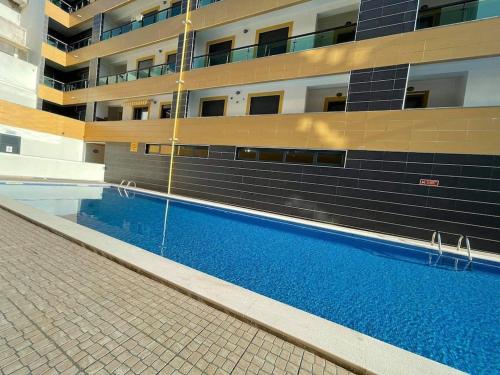 ein Gebäude mit einem Pool vor einem Gebäude in der Unterkunft Apartamento Cacela- Manta Rota- Altura in Vila Nova De Cacela