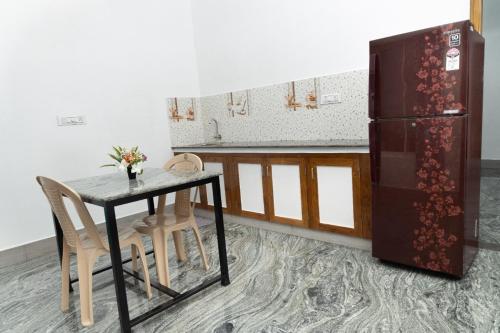a kitchen with a table and a refrigerator at BrightMoon_Homestay in Puducherry