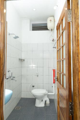 a white bathroom with a toilet and a sink at BrightMoon_Homestay in Puducherry