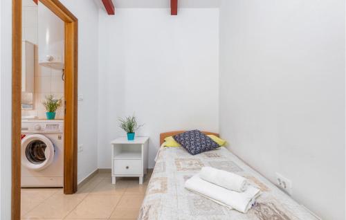 een slaapkamer met een bed en een wasmachine bij Amazing Home In Rovinj With Kitchen in Rovinj