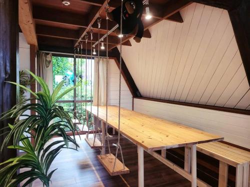 a wooden table in a room with a plant at LOGIN OKINAWA -plants- in Onna