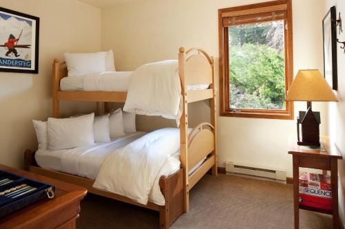 a bedroom with two bunk beds and a window at Juniper Springs Resort in Mammoth Lakes