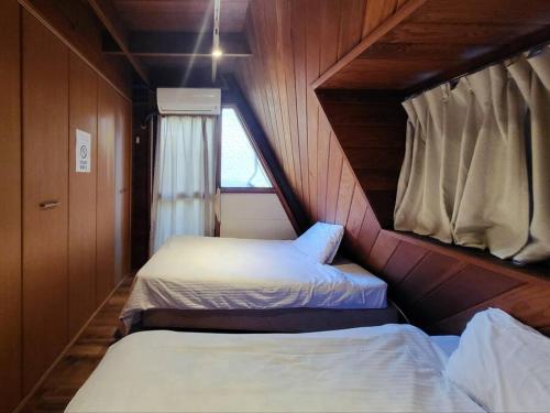 a room with two beds in a small room at LOGIN OKINAWA -plants- in Onna