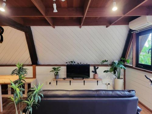 a living room with a couch and potted plants at LOGIN OKINAWA -plants- in Onna