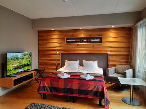 a hotel room with a bed and a television at Levi Suites Unna Mànnu in Levi