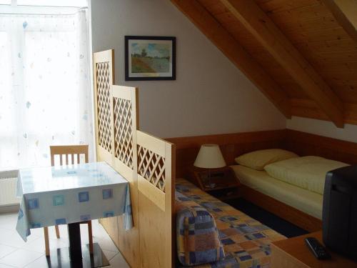 Gasthof zur Sonne في شتوتغارت: غرفة نوم بسرير وطاولة وتلفزيون