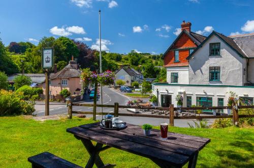 a wooden table sitting in the grass next to a street at The Crown Hotel in Exford