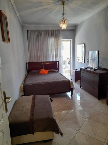 1 Schlafzimmer mit 2 Betten, einer Kommode und einem TV in der Unterkunft Lititsia apartment in Thessaloniki