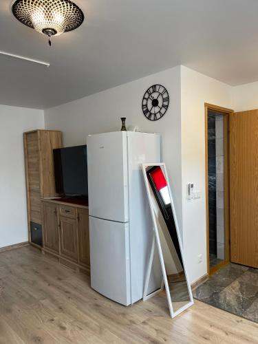 a white refrigerator in a kitchen with a clock on the wall at Paralepa Guest House in Haapsalu
