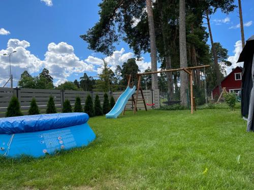 a playground with a slide in a yard at Paralepa Guest House in Haapsalu