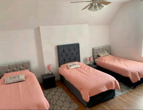 a bedroom with two beds and a ceiling fan at Beach house in Crosby