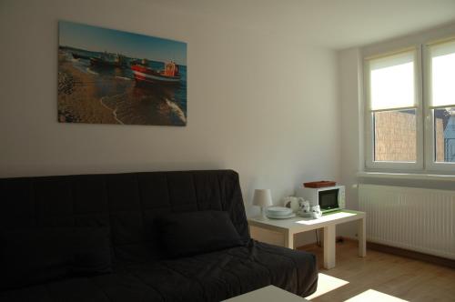 a living room with a couch and a table at Apartamenty sopot-topos in Sopot