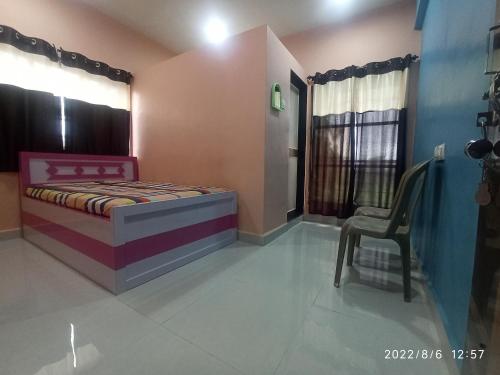 - une chambre avec un lit et une chaise dans l'établissement Priyansh Home stay, à Harihareshwar