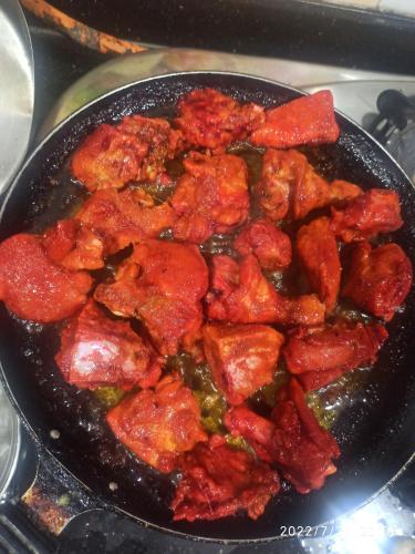 a frying pan filled with food on a stove at Priyansh Home stay in Harihareshwar