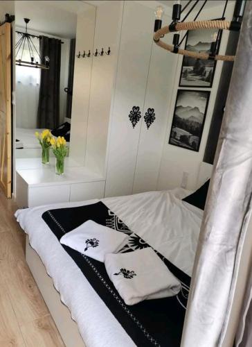 a bedroom with a bed with two pillows on it at Apartament SMALL Czarny Potok in Krynica Zdrój