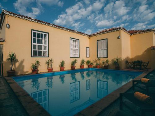 uma piscina em frente a uma casa em Hotel Rural La Casa Amarilla em Los Silos
