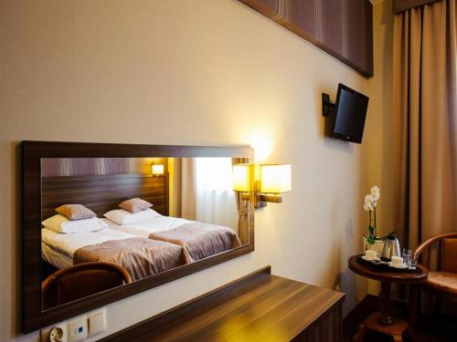 a bedroom with a large mirror on the wall at Hotel Sevilla in Rawa Mazowiecka