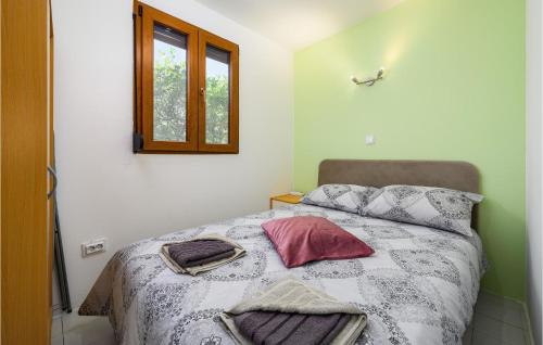 ein Schlafzimmer mit einem Bett mit Kissen und einem Fenster in der Unterkunft 2 Bedroom Gorgeous Apartment In Rovinjsko Selo in Rovinjsko Selo