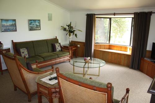 a living room with a couch and a table at Ahstyk Cottage in Burnt Pine