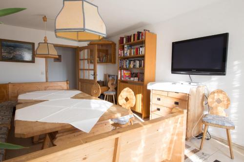 a bedroom with a wooden table and a tv at Landgasthof Bieg in Neuler