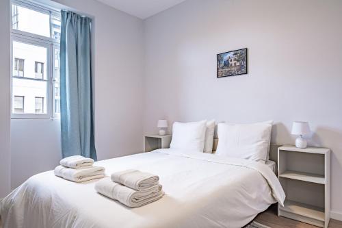 Un dormitorio con una cama blanca con toallas. en CASA DA ROCHINHA en Funchal