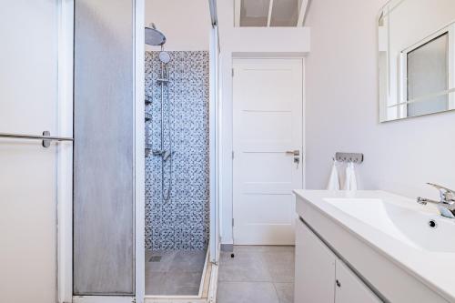 baño blanco con ducha y lavamanos en CASA DA ROCHINHA, en Funchal