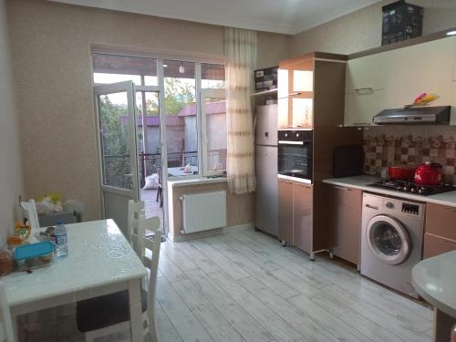 a kitchen with a table and a stove and a sink at SUNRISE Guest House in İsmayıllı