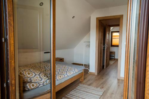 a small bedroom with a bed and a mirror at Domki przy Alei in Krasnobród
