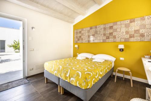 a bedroom with a bed with a yellow wall at I Gelsomini Guest House in Noto