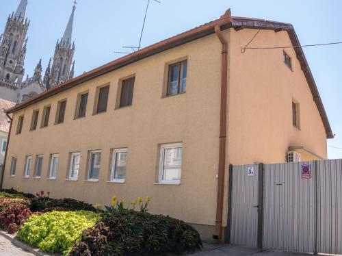 ein Gebäude mit einem Zaun vor einer Kirche in der Unterkunft Gerardus Apartmani in Vršac