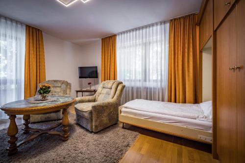 een slaapkamer met een bed, een stoel en een tafel bij Ferienwohnung Sophia in Bad Reichenhall