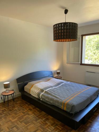 une chambre avec un lit et deux tables et une fenêtre dans l'établissement Appartement 110m2 A 2 KM DE LA PLAGE DE ST GEORGES DE DIDONNE, à Saint-Georges-de-Didonne