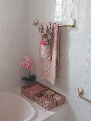a bathroom with a bath tub with a box of flowers at Eagle House in Sao Pedro de Tomar
